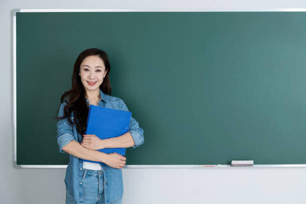 istock Woman holding file in front of blackboard 1193310877