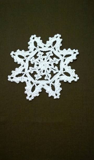 Crocheted white vintage snowflake on dark background. Place for text, copy space. Handmade festive winter decor for Christmas holiday. Knitted napkin. Xmas ornaments and decorations. Happy New Year. copo de nieve vintage blanco croché sobre fondo oscuro. coloque el texto, copie el espacio. decoración de invierno festivo hecha a mano para las vacaciones de navidad. servilleta de punto. adornos y decoraciones navideñas. feliz año nuevo.