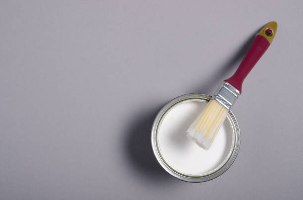 istock Open can with white paint and brush 1193312475