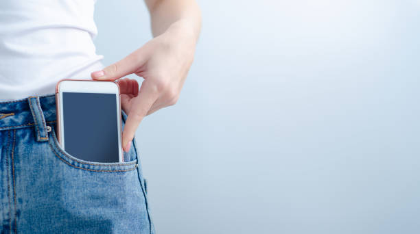 la femme met le téléphone portable dans la poche de jeans - pocket photos et images de collection