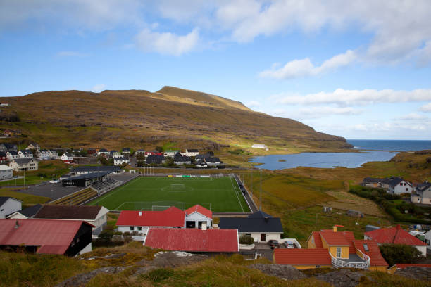 Football field in Eidi, Faroe Islands Scenic panoramic landscape of a picturesque village of Eidi with football stadium and traditional houses on the Faroe Islands eysturoy photos stock pictures, royalty-free photos & images