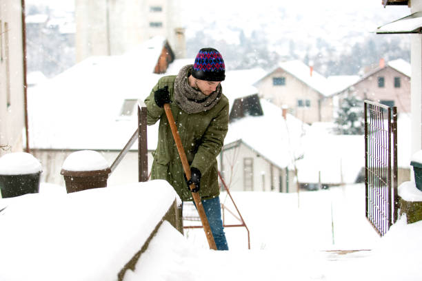 istock Man with shovel cleaning snow at day light in his backyard 1193315595