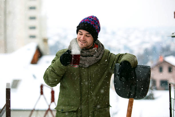 istock Young man resting and drinking tea after clearing snow 1193316393