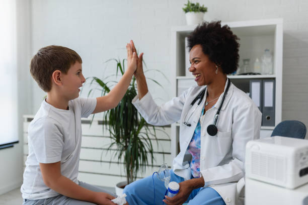 istock Smiling female afro american doctor general practitioner talks and amuses child before medical examination 1193316425