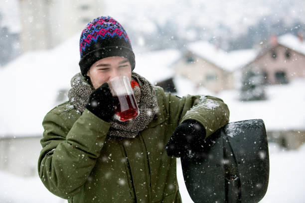 istock Young man resting and drinking tea after clearing snow 1193316741