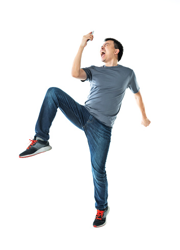 Excited man holding mobile phone on white background.
