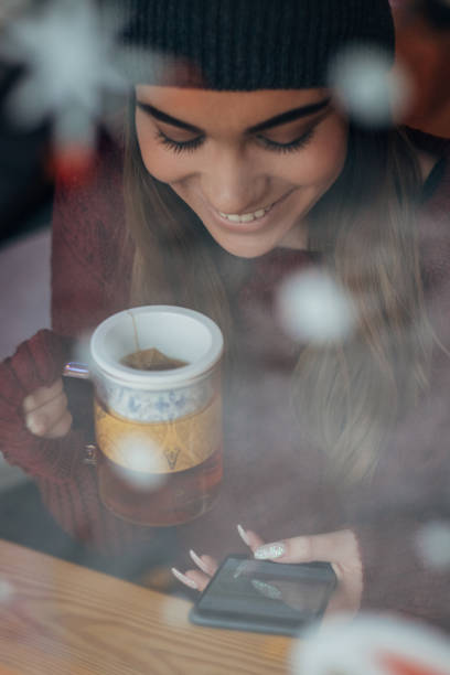 istock Cheerful young woman is having tea and text messaging 1193318634