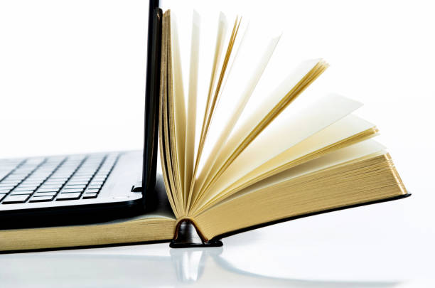 istock Laptop and open book on white background 1193320257