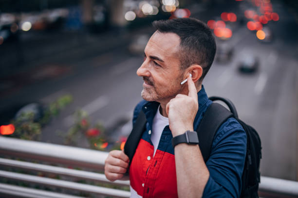 istock Mature man with backpack is listening to music 1193320276