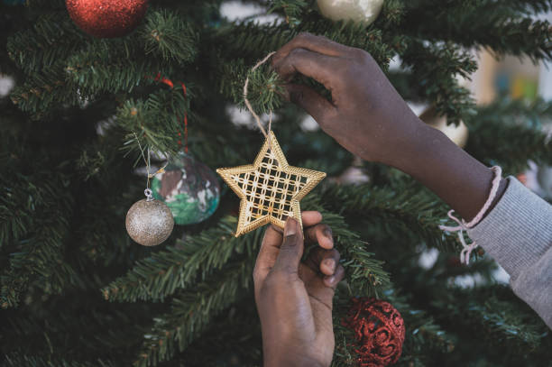 istock Girl hanging an ornament on Christmas tree 1193321679