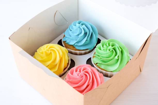 istock Set of four multi-colored cupcakes in a box. 1193323058