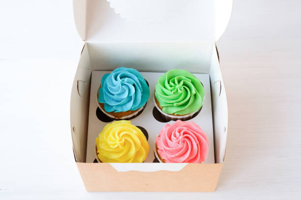 istock Set of four multi-colored cupcakes in a box. 1193323107