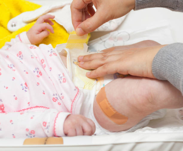 istock Cropped Hands Changing Diaper Of Baby 1193328062