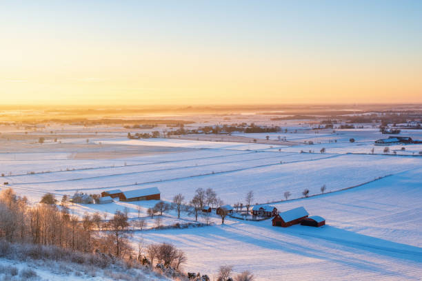 Winter landscape view in the sunset with a farm