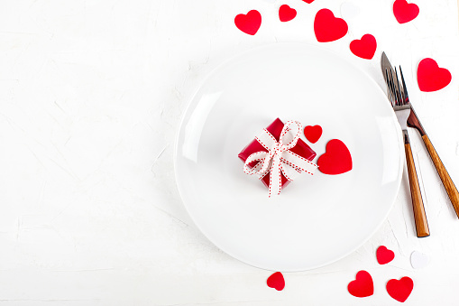 Holiday table setting with red gift box for Valentines day, top view, copy space