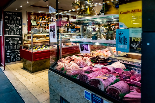 A butcher store in Paris, France with produce laid out in the window at the front of the shop.