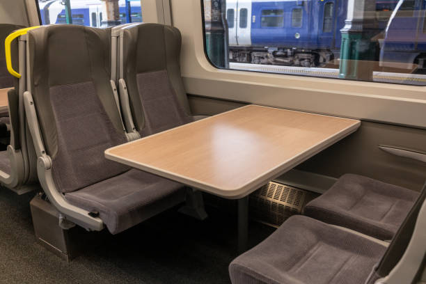Empty seats and table in a British train Unoccupied seats and a table inside a train in the UK. train interior stock pictures, royalty-free photos & images