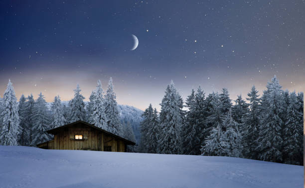istock Illuminated wooden hut in a winter night 1193337292