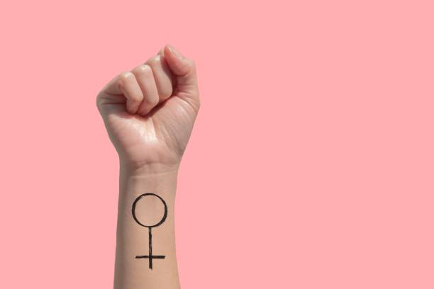 una donna mano e femminista firmano tatuaggi sulla mano isolano su sfondo rosa - potere femminile foto e immagini stock