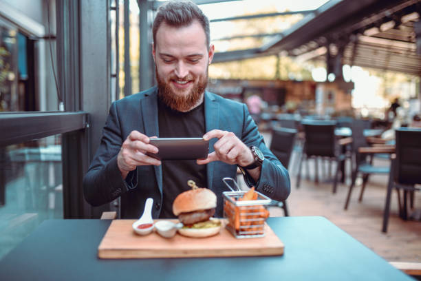 istock Smiling Elegant Male Photographing Beautiful Burger 1193339176