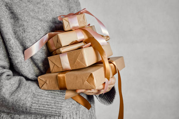 Woman holds a Christmas present in hands. Happy holiday, gift box close-up. Surprise for Boxing day, Christmas and New Year party. Magic time. Celebration winter event. Wrapping paper, toys and ribbon la mujer tiene un regalo de navidad en las manos. feliz fiesta, caja de regalo de primer plano. sorpresa para el día del boxeo, navidad y fiesta de año nuevo. tiempo mágico. evento de invierno de celebración. papel de envoltorio, juguetes y cinta