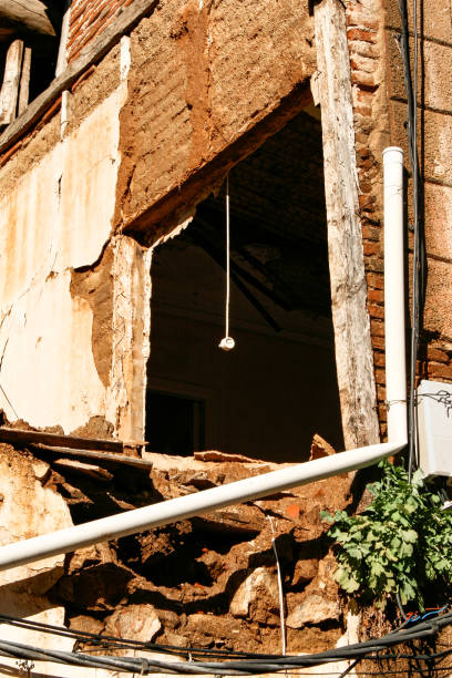 istock Collapsed and abandoned building with a plug hanging from a window without glass 1193342330