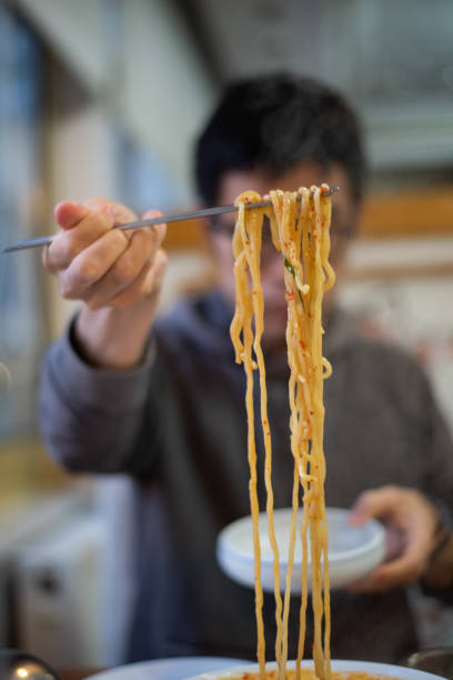 istock Man eating a bowl of noodles 1193343246