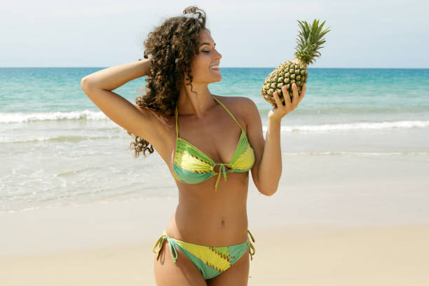 istock Woman with a pineapple fruit on the beach 1193344082