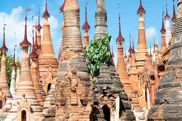 Shwe Inn Thein Paya Buddhist Stupas stand as sentinels of the dead, Inle, Myanmar Shwe Inn Thein Paya Buddhist Stupas or memorial Zedi, cluster together like a fairytale castle, a Unesco landmark temple of unique architecture and over a thousand spires, many in gold, brick and stucco, dedicated in remembrance to the lives of notable Buddhists in this ancient religious pagoda at Indein village, Taunggyi, Myanmar sentinel spire stock pictures, royalty-free photos & images