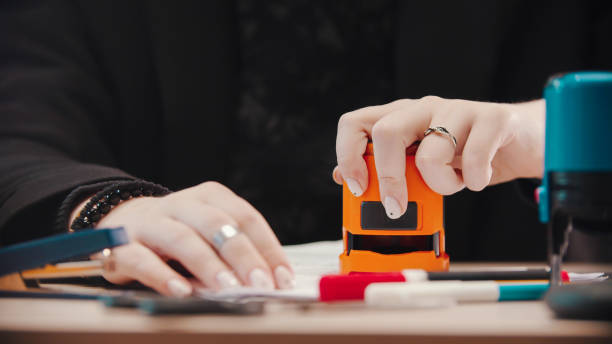 istock office concept - putting a stamp on the document with a orange stamping 1193348122