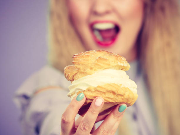 istock Funny woman holds cream puff cake 1193349451