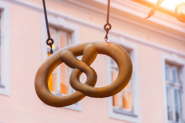 Pretzel in the form of a sign of a bakery cafe on the streets of Europe. Pretzel in the form of a sign of a bakery cafe on the streets of Europe business architecture blue people stock pictures, royalty-free photos & images
