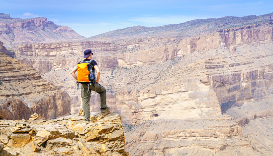 A hiker is enjoying the view of the canyon in Jebel Shams Mountain in Oman