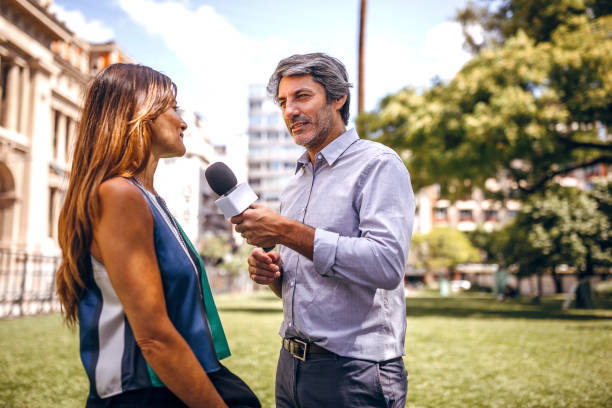 Journalist asking a few questions Man having interview for TV with attractive woman, asking a few questions on the street media interview photos stock pictures, royalty-free photos & images