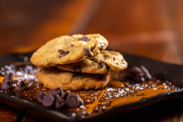 On a wooden table and platter Chocolate Chip Cookies served from various angles and perspectives for variety (Shot with Canon 5DS 50.6mp photos professionally retouched - Lightroom / Photoshop - original size 5792 x 8688 downsampled as needed for clarity and select focus used for dramatic effect)