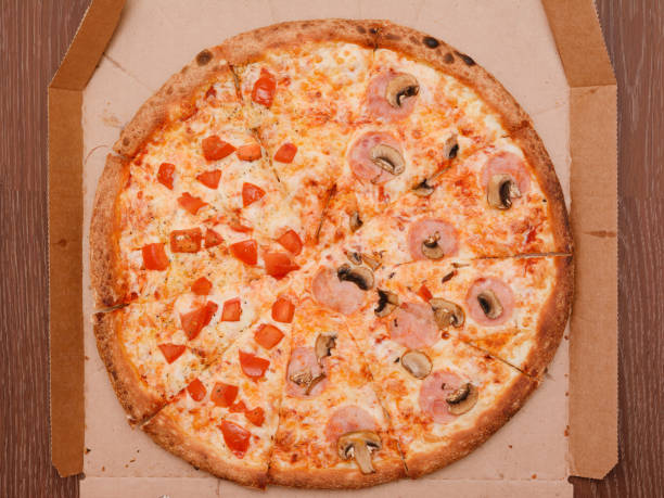 istock Round big pizza in a cardboard box. The view from the top 1193362841
