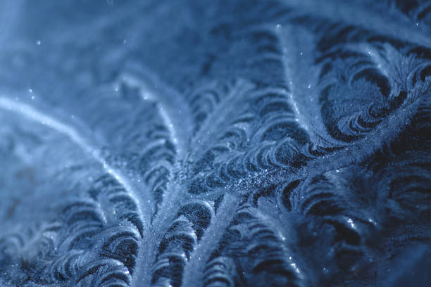 istock Frosty pattern on car glass in blue tones. 1193364670