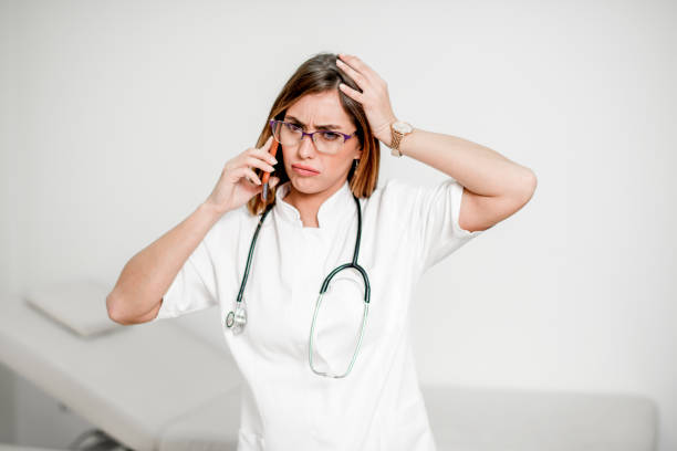 istock Attractive young female doctor talking on mobile phone 1193365343