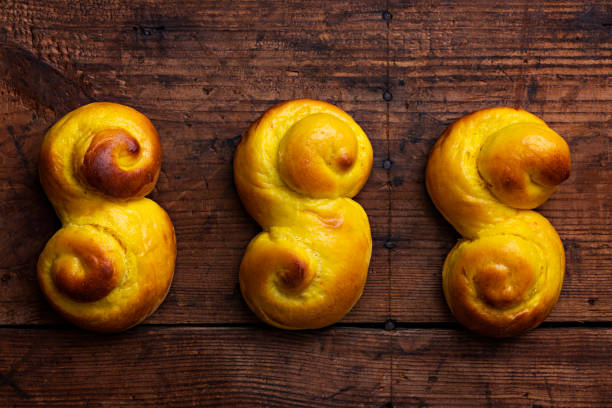 schwedische traditionelle weihnachtsbrötchen lussekatter oder lussebullar auf einem rustikalen holztisch hintergrund - lucia bun stock-fotos und bilder