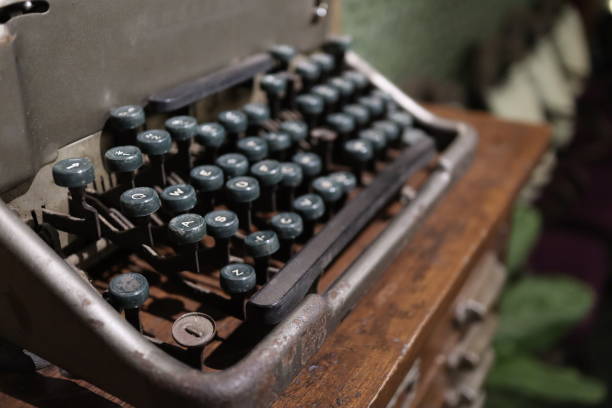 a closeup image of an old vintage type writer with eroded keys with selective focus on a s d w keys and background blur - typewriter sepia toned old nostalgia imagens e fotografias de stock