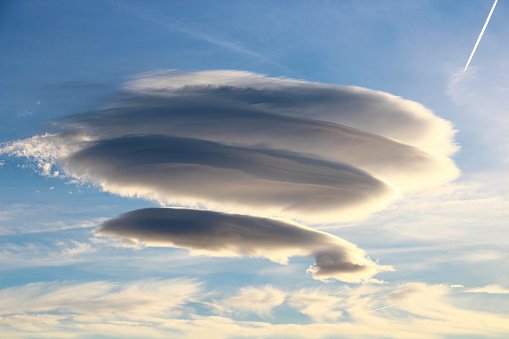 Lenticular circular clouds over the blue sky