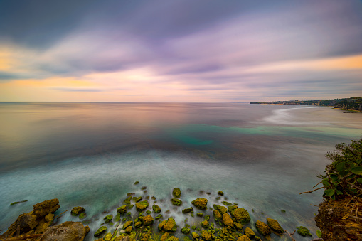 Long exposure dramatic tropical sea and sky sunset, Longexposure shot Colored sky over ocean coast on sunset time background.