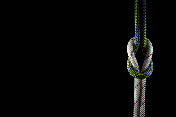 tied knot in climbing/sailing rope isolated on black background stock photo