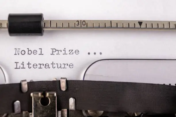 The inscription "nobel prize in literature" on a white sheet in a typewriter. Nobel prize in literature. Light background.