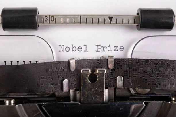 The inscription "nobel prize" on a white sheet in a typewriter. Nobel prize in literature. Light background.