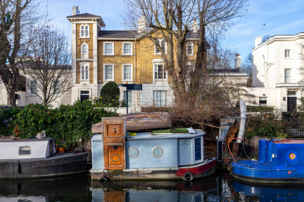 Picturesque houseboat in Little Venice, West London Blue small boat in the canal and a wealthy residential house in the background little venice london stock pictures, royalty-free photos & images