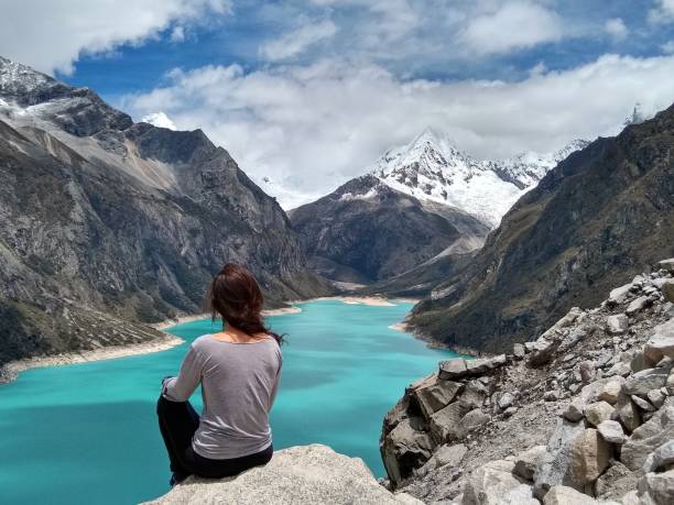 Girl at Laguna Paron, Huaraz, Peru. A blue-green lake in the Cordillera Blanca on the Peruvian Andes. stock photo