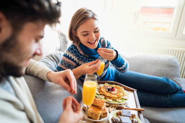 Young Caucasian love couple enjoying a romantic brunch at home.