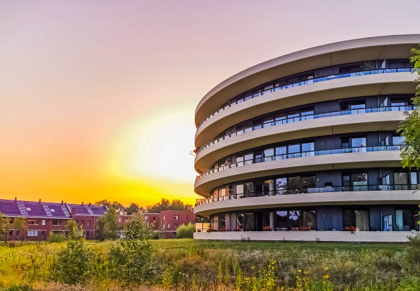 современное здание апартаментов во время заката в городе апелдорн, нидерланды, голландская архитектура - apeldoorn стоковые фото и изображения