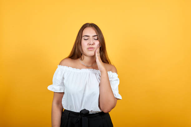 istock Sick young woman keeping hand on cheek, headache 1193388152
